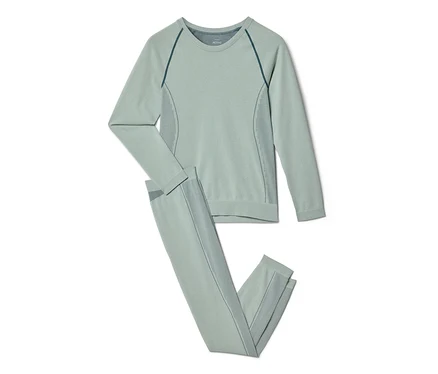 Haut à manches longues vert clair et leggings assortis avec des coutures raglan vert foncé et des détails à rayures verticales.