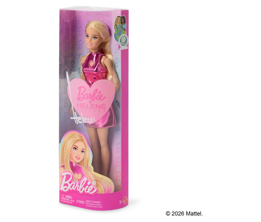 Une poupée Barbie blonde dans une boîte en plastique transparent, vêtue d'une robe métallique rose brillante et tenant une pancarte en forme de cœur rose avec l'inscription « Barbie Helene Fischer ».