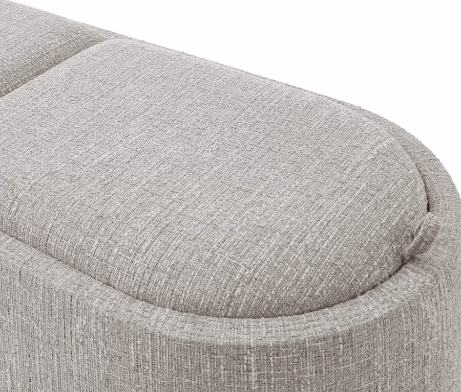 Gros plan d'un tissu d'ameublement texturé gris clair avec des bords arrondis, faisant partie d'un meuble.