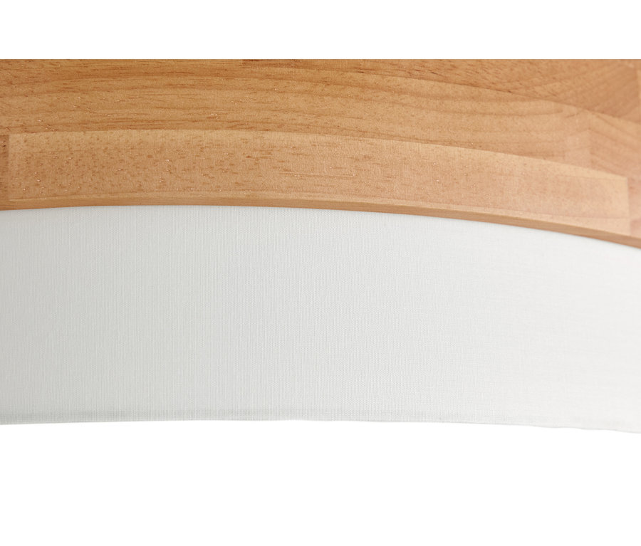 Gros plan d'une surface en bois clair avec un bord incurvé au-dessus d'un tissu blanc texturé.