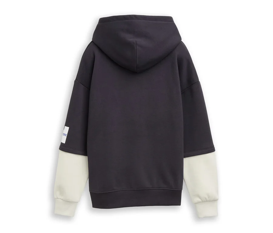 Vue de dos d'un sweat à capuche gris foncé avec des manches beige clair et une petite étiquette blanche sur la manche gauche.
