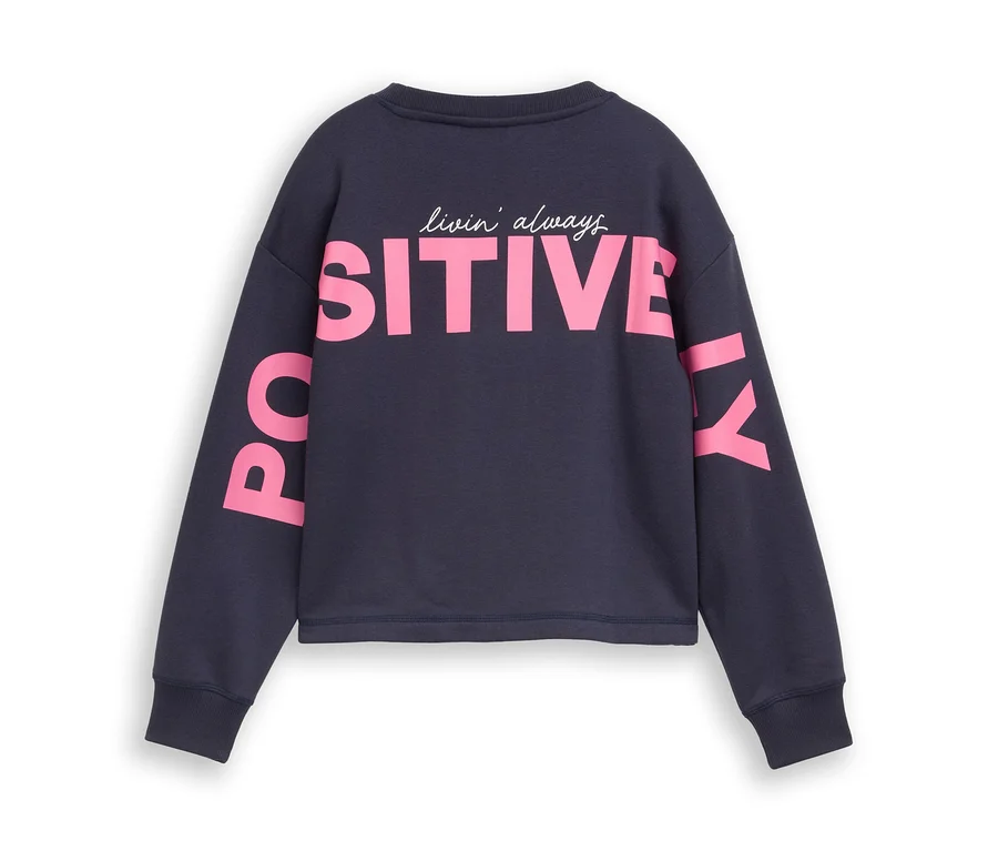 Sweat-shirt bleu marine avec l'inscription "livin' always POSITIVELY" en rose et blanc sur le dos et les manches.