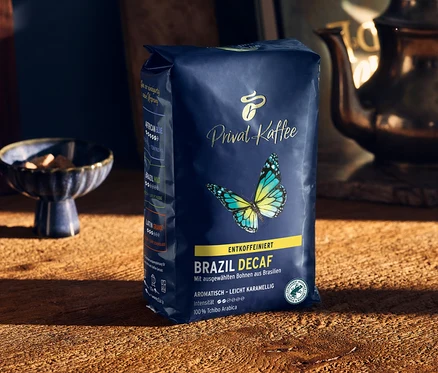 Un paquet de café Privat Kaffee Brazil Decaf est posé sur une table en bois.