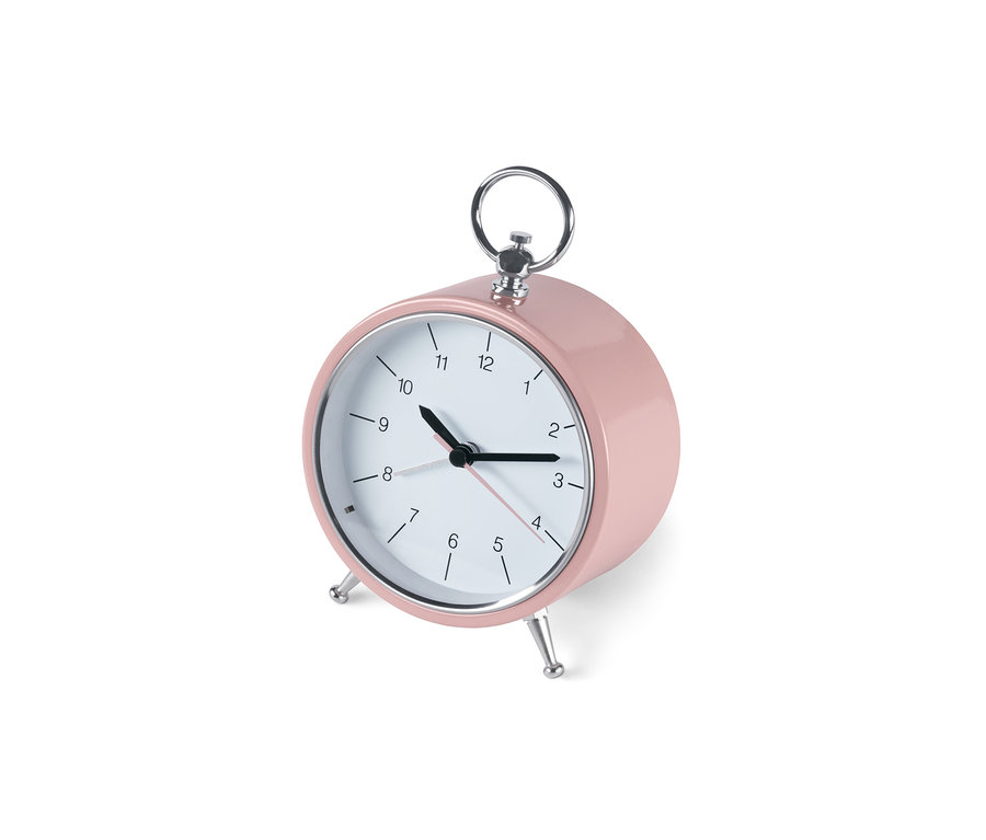 Un réveil analogique rétro rose est posé sur un fond blanc. Les aiguilles indiquent 10h14.