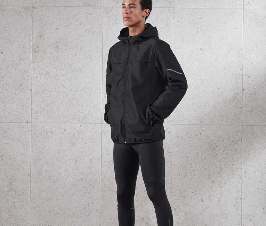 Un homme portant une veste coupe-vent noire.