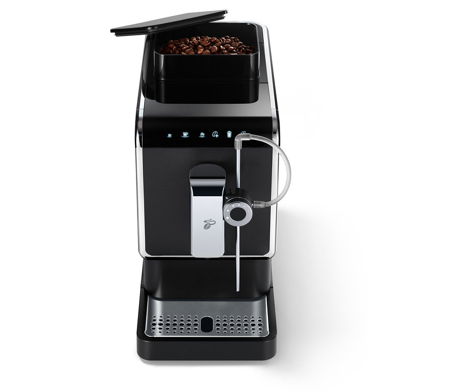 Une machine à café entièrement automatique de Tchibo « Esperto Pro » anthracite avec un récipient à grains de café ouvert.