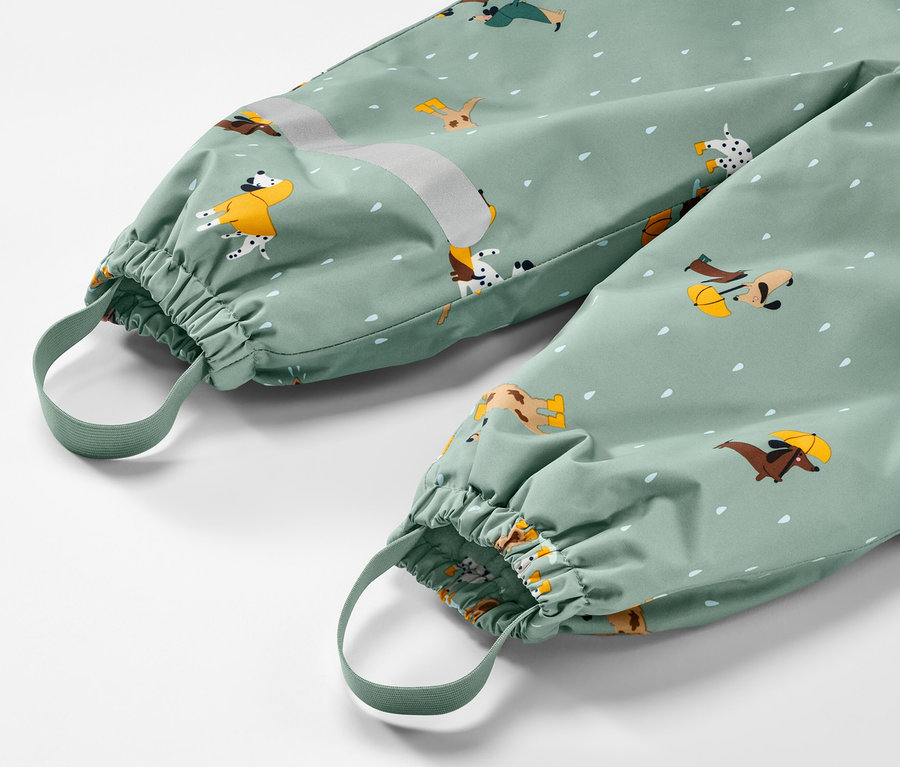 Gros plan sur un pantalon de pluie thermique pour enfant avec un motif de chien.