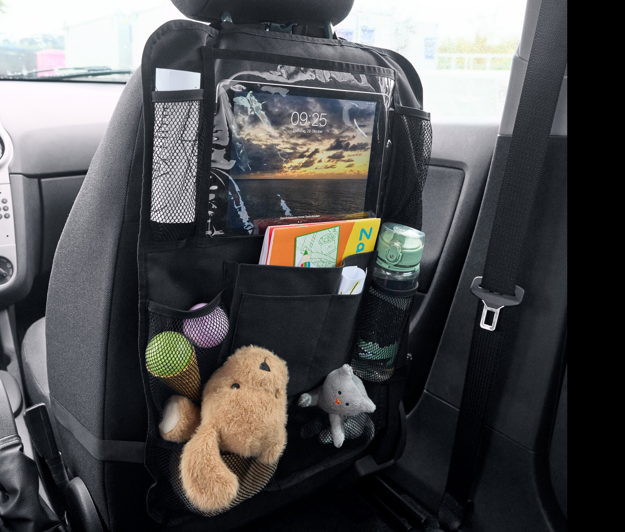 Organisateur de siège arrière noir avec jouets, livres et tablette.