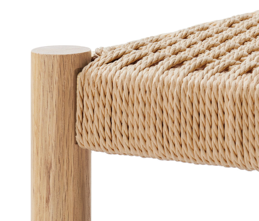 Détail d'un banc en bois avec assise tressée.