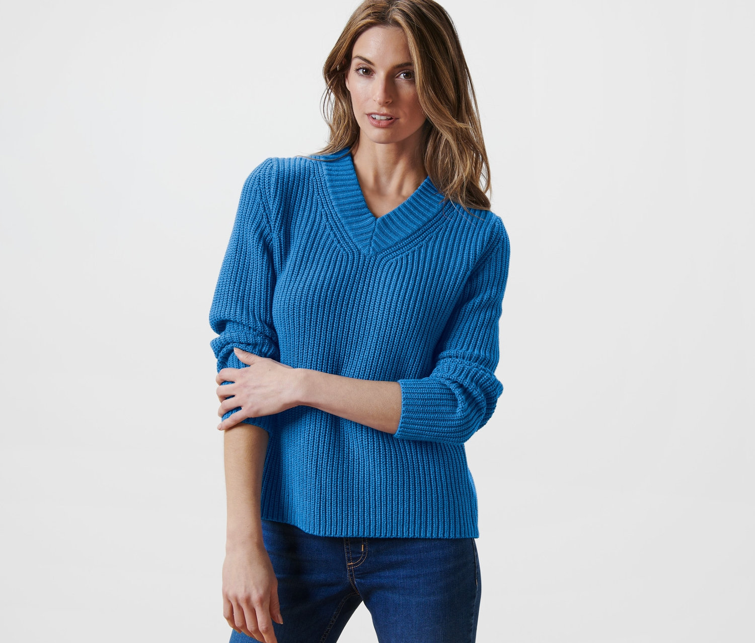 Femme posant dans un pull en maille bleu.