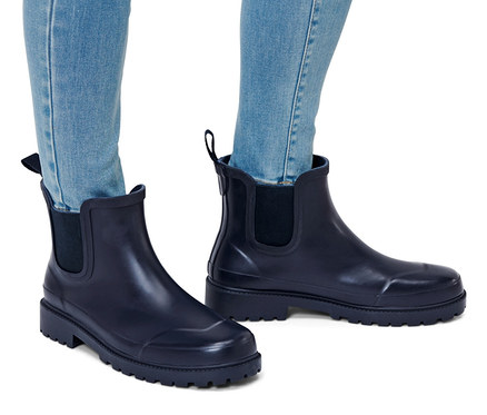Jambes en jean et bottines de pluie.
