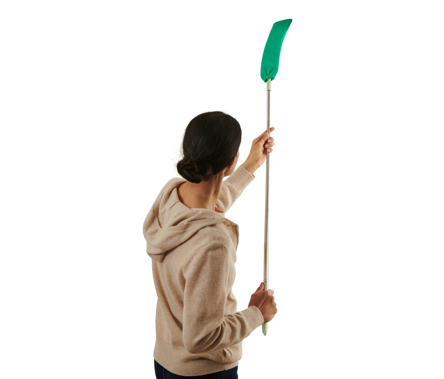 Femme utilisant un attrape-poussière flexible avec une tige télescopique.