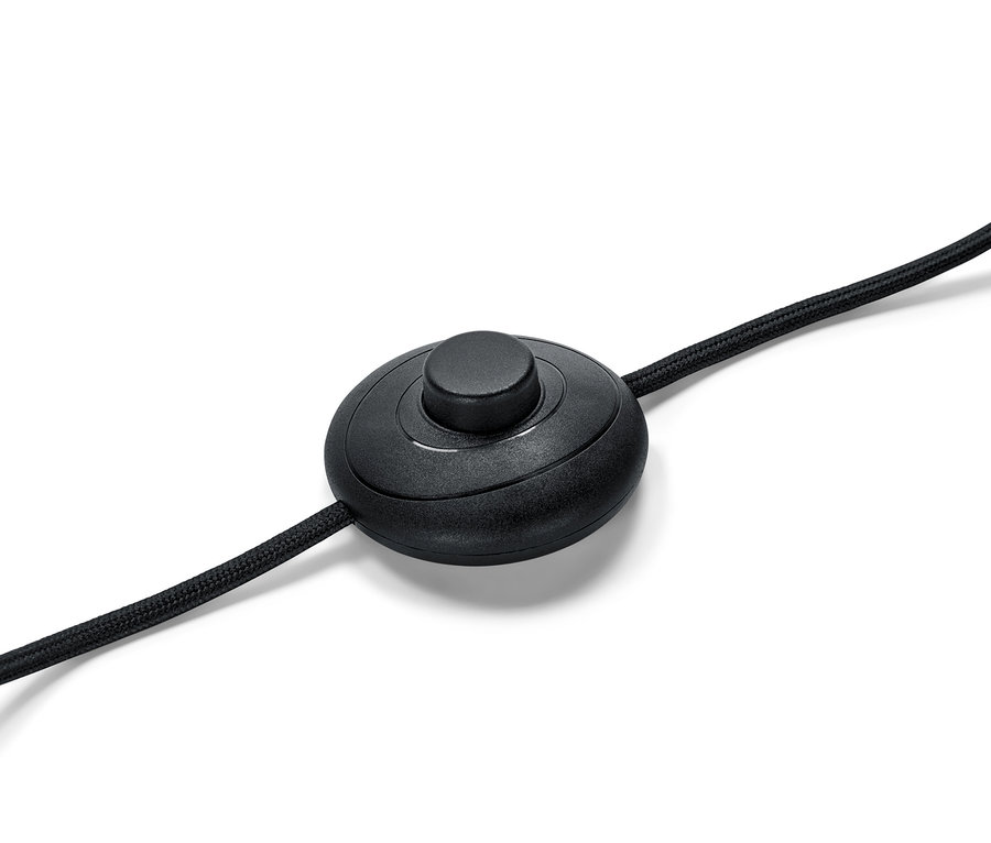 Gros plan d'un interrupteur au pied noir pour lampadaire sur fond blanc.