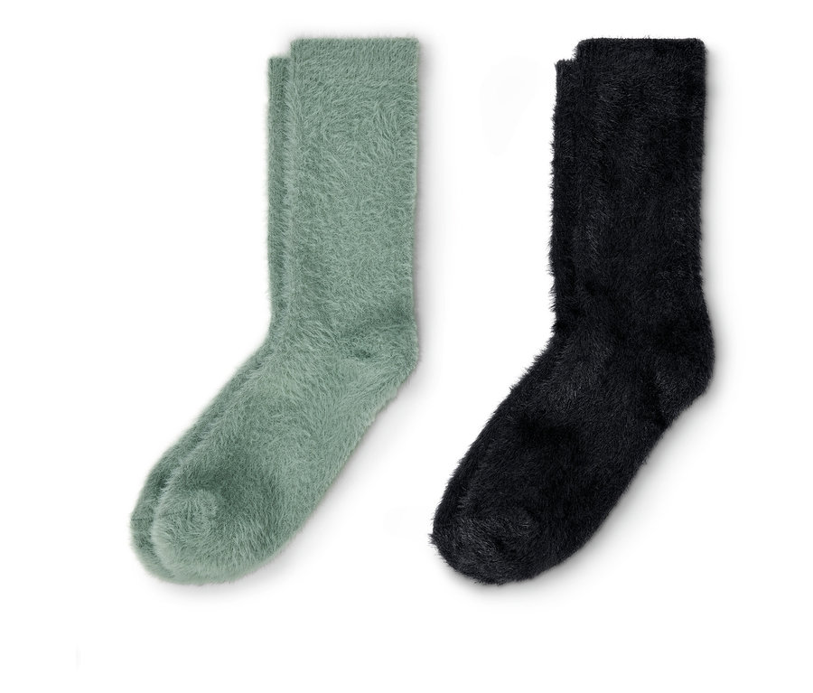 Une paire de chaussettes douillettes vertes et une paire de chaussettes douillettes noires avec fil d'effet sont posées côte à côte.