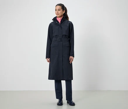 Une femme porte un long manteau noir avec une ceinture.