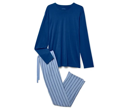 Un haut de pyjama bleu à manches longues et un pantalon rayé sont posés sur un fond blanc.