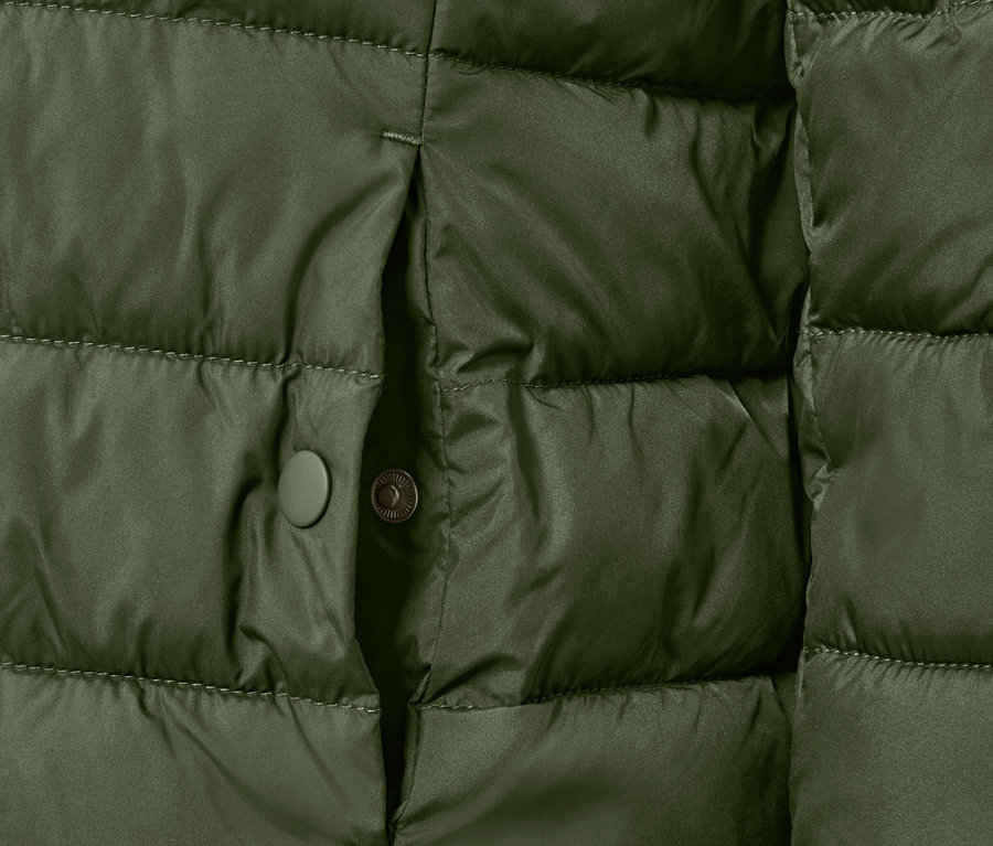 Gros plan sur une veste matelassée verte avec un bouton