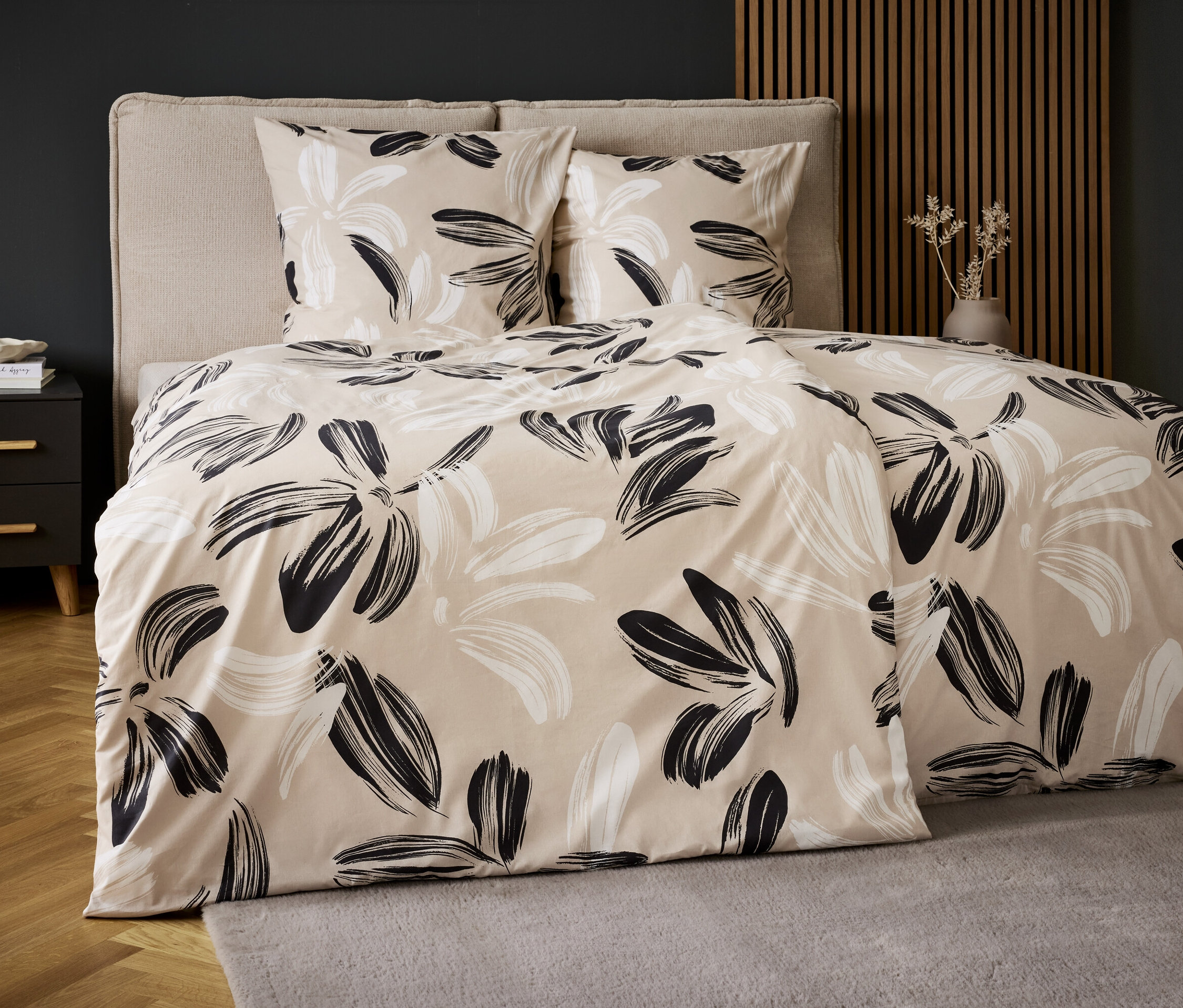 Ensemble de literie avec un motif floral sur un fond beige. Deux oreillers et une couette.