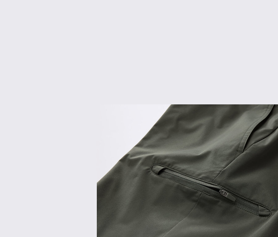 Gros plan d'un pantalon technique kaki 2 en 1 avec une poche zippée.