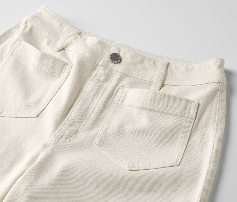 Détail d'un jean flare crème – Coupe «

 Cara 

» avec poches.