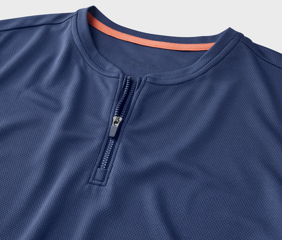 Gros plan sur un t-shirt de sport bleu à demi-fermeture éclair.