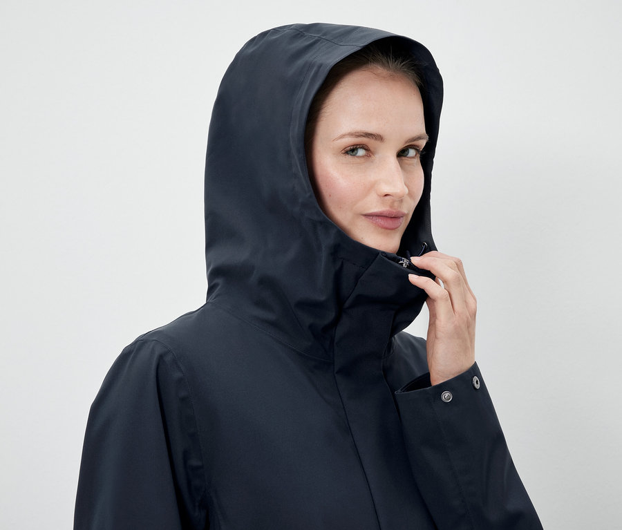 Femme portant une veste bleu marine à capuche.