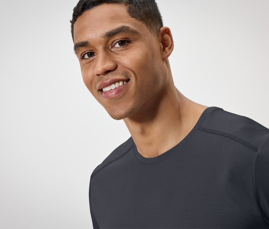 Portrait d'un homme souriant portant un t-shirt noir.