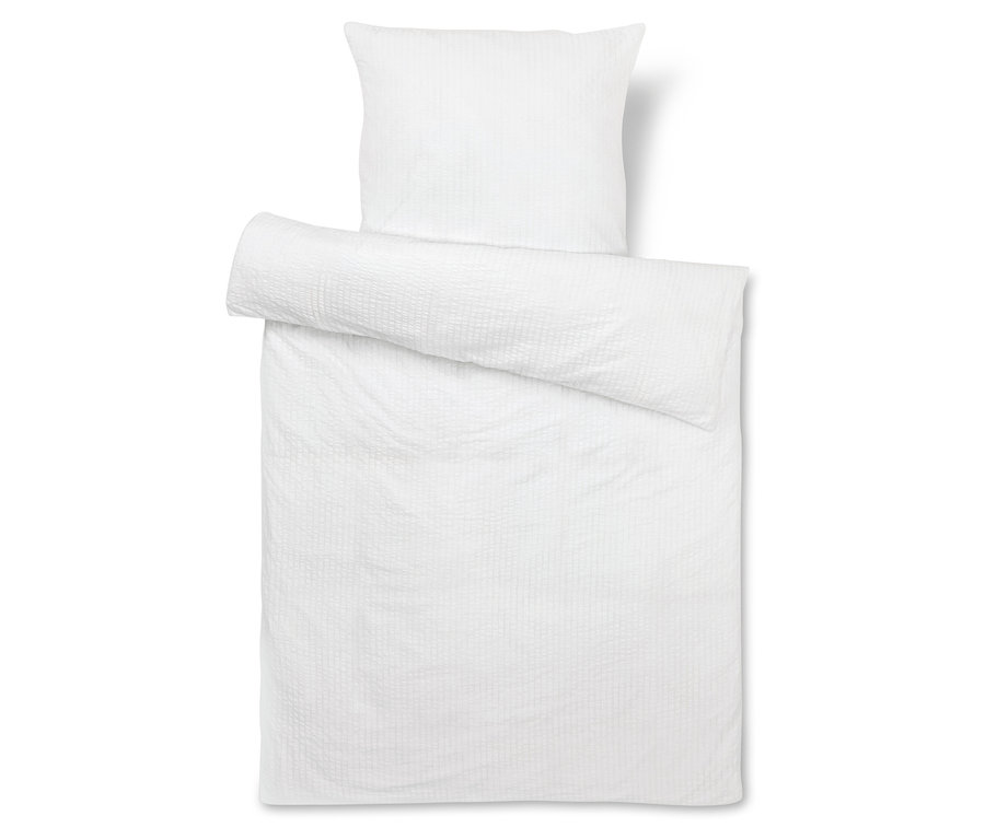 Linge de lit blanc avec taie d'oreiller.