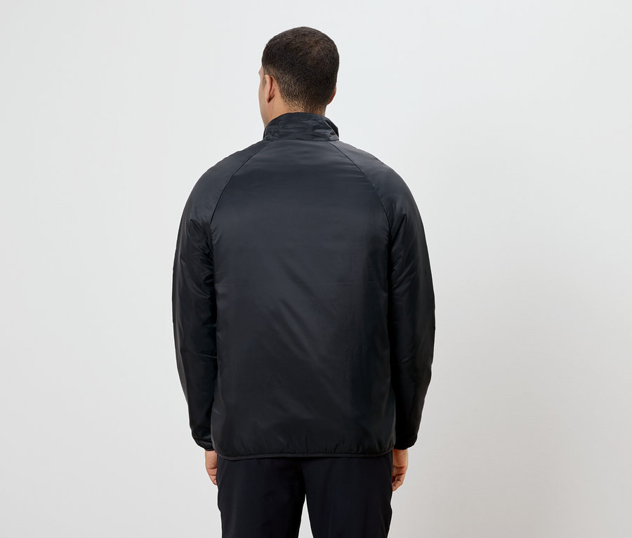 Un homme, vu de dos, porte une veste et un pantalon noirs.