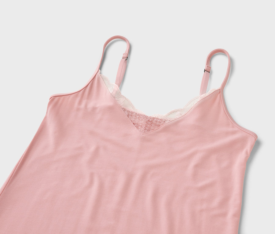 Une chemise de nuit rose avec de la dentelle sur fond blanc.