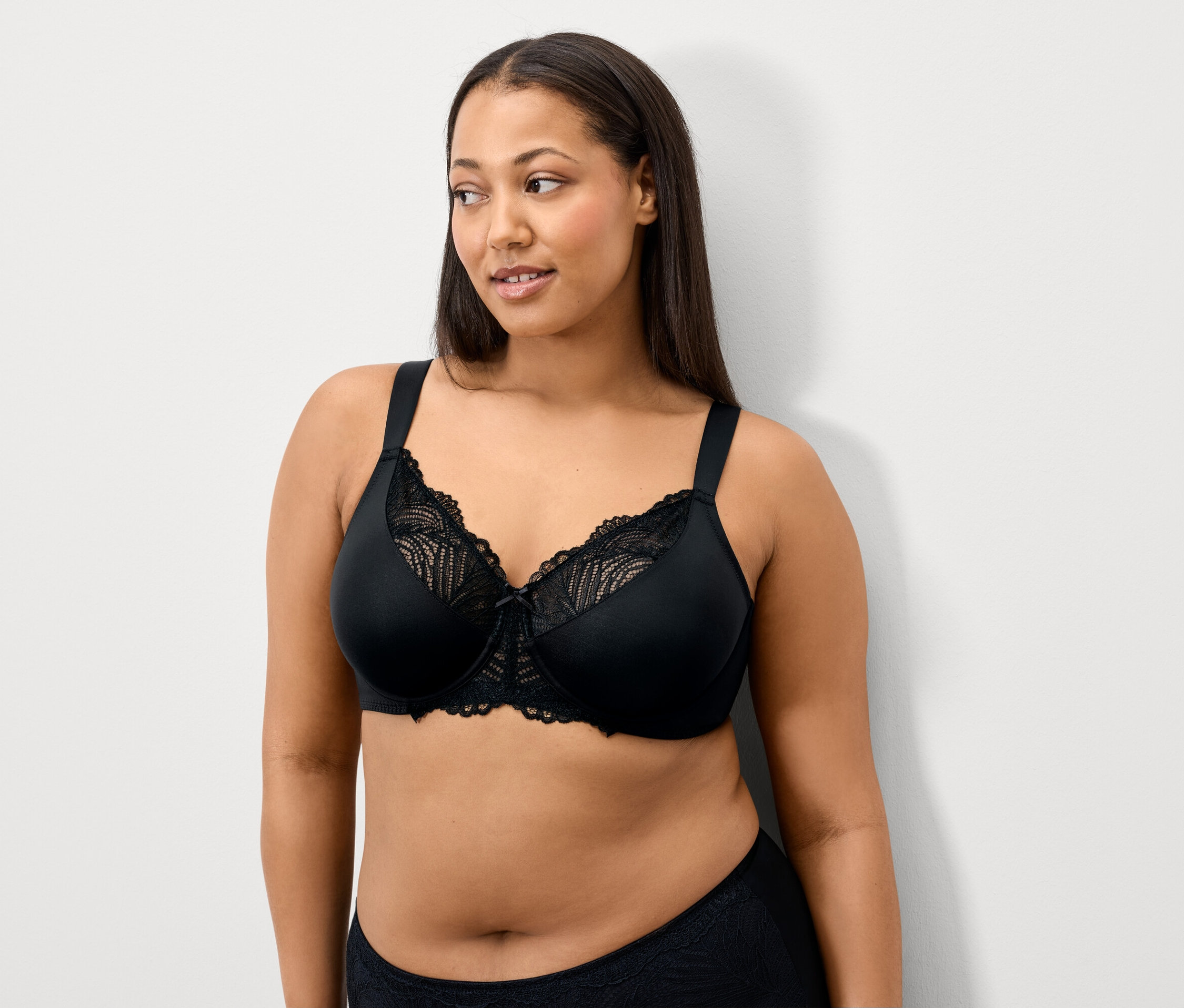 Une femme porte un soutien-gorge en dentelle noire.