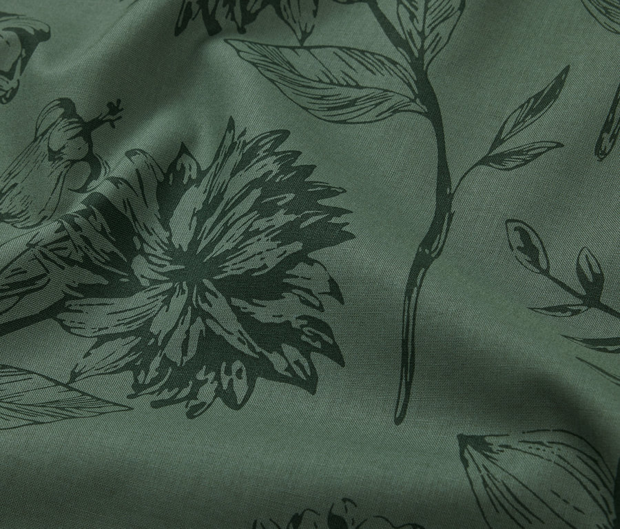 Gros plan d'une parure de lit en renforcé vert de taille standard avec un imprimé floral.