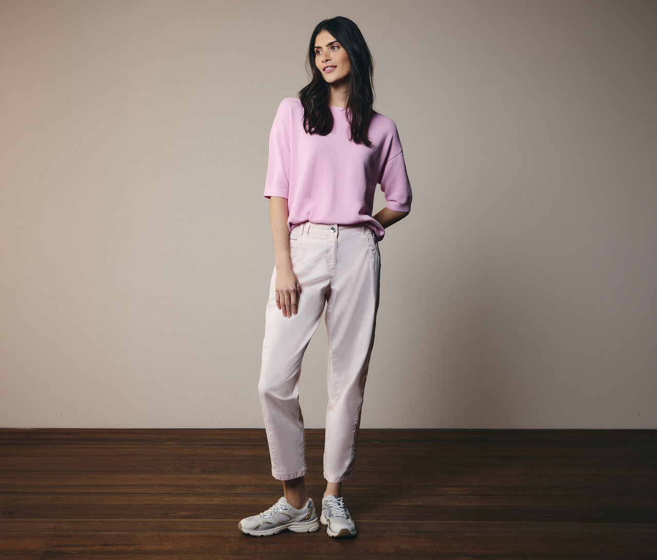 Femme portant un pantalon rose clair et un pull à manches courtes CECIL avec des baskets grises.