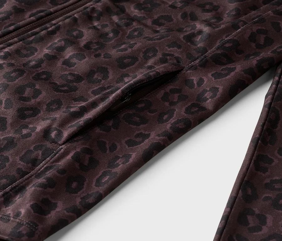 Gros plan d'une veste marron à imprimé léopard avec fermeture éclair, poche zippée incluse.