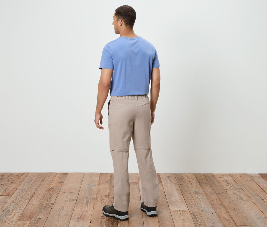 Homme de dos portant un pantalon beige et un t-shirt bleu