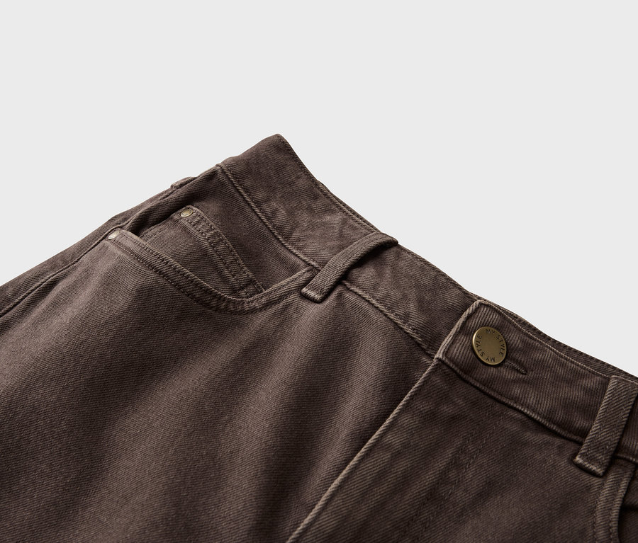 Gros plan d'un jean marron avec fermeture à bouton et poche.