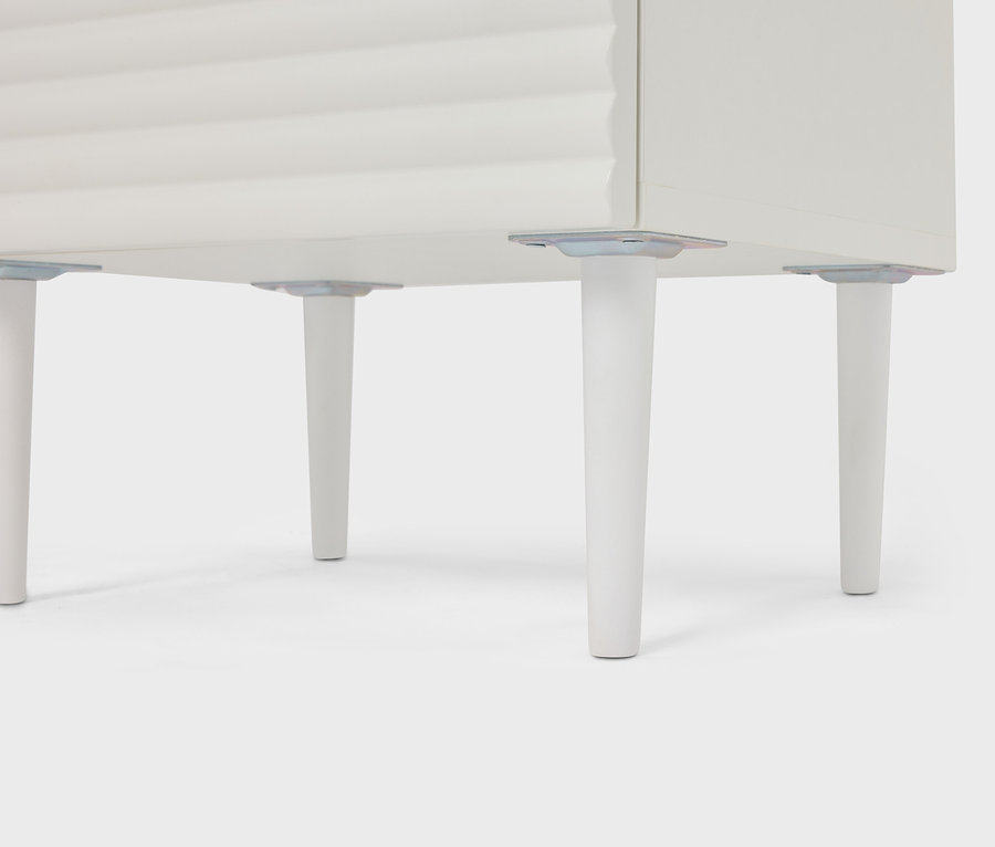 Vue détaillée d'une armoire blanche avec quatre pieds coniques.