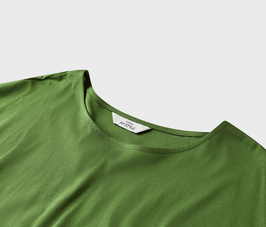 Gros plan d'un t-shirt vert avec une étiquette blanche au niveau de l'encolure.