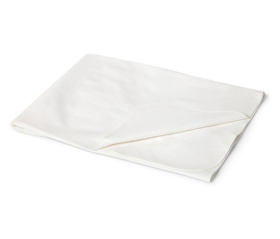 Gros plan d'une couverture de bébé crème pliée avec des coins arrondis sur un fond blanc.