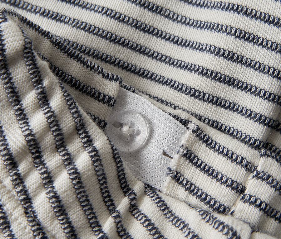 Vue détaillée d'un tissu rayé avec une fermeture boutonnée.
