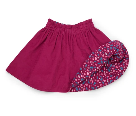 Une jupe en velours côtelé bordeaux avec une taille élastique est posée à côté d'une jupe retroussée à motifs floraux.