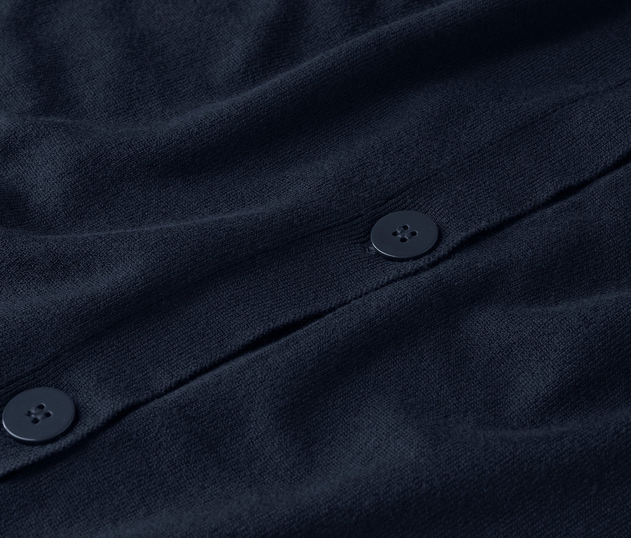 Gros plan sur un cardigan en tricot bleu marine avec des boutons.