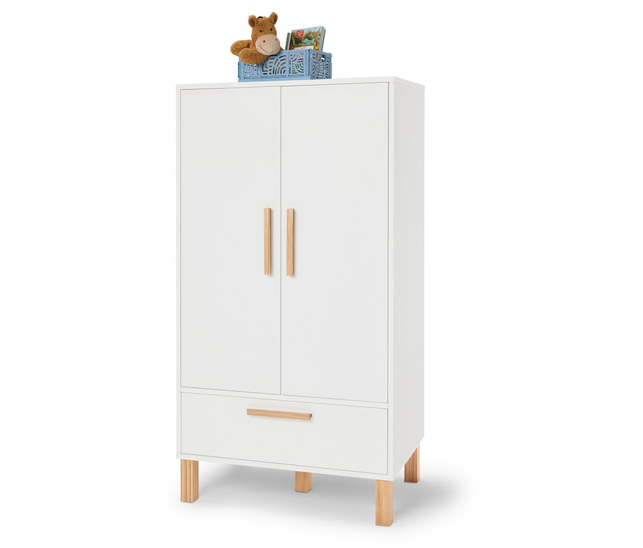 Armoire blanche avec des détails en bois, sur laquelle se trouve une boîte bleue contenant une peluche et des livres.
