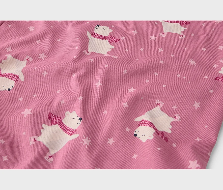 Tissu rose avec un motif d'ours polaires blancs patinant, portant des écharpes rouges et entourés d'étoiles blanches.