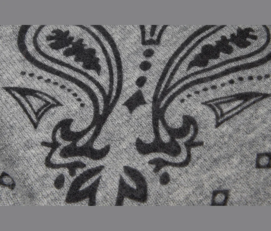 Gros plan sur un bandana tricoté en laine et cachemire gris, présentant un motif cachemire gris foncé.