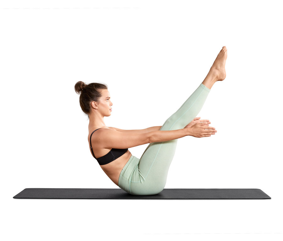 Femme faisant du yoga sur un tapis de yoga et de fitness noir.