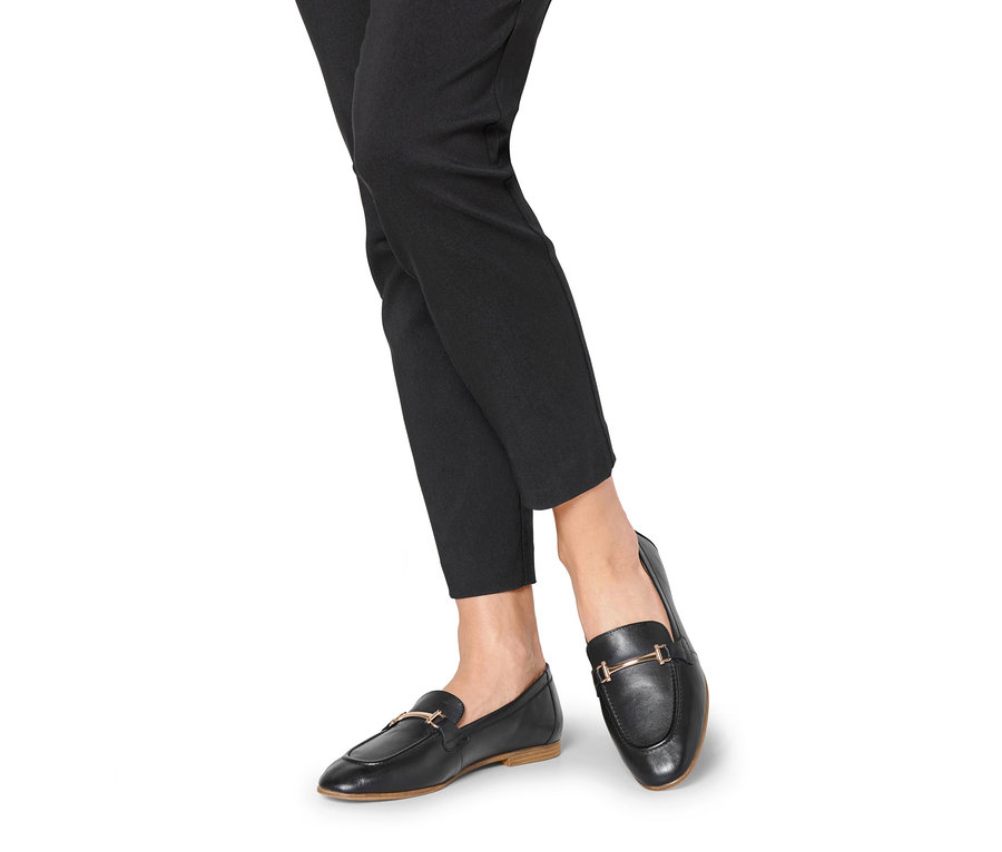 Jambes en pantalon noir et mocassins en cuir.