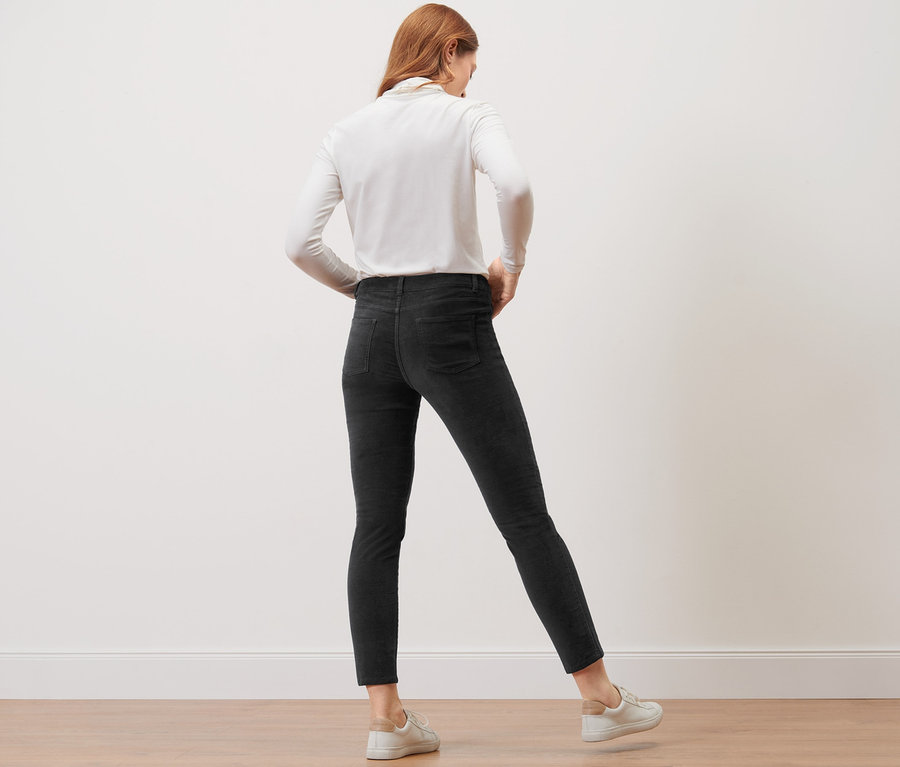 Une femme, vue de dos, porte un pantalon en velours noir.