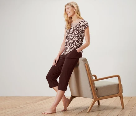 Une femme blonde est assise sur un fauteuil en pyjama avec de la dentelle.