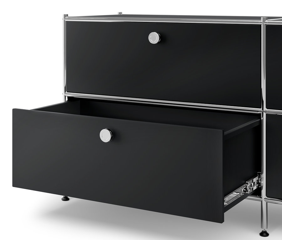 Détail d'une commode en métal noire « CN3 » avec 6 tiroirs et d'un meuble bas en métal « CN3 » avec 4 tiroirs, dont un tiroir est ouvert.